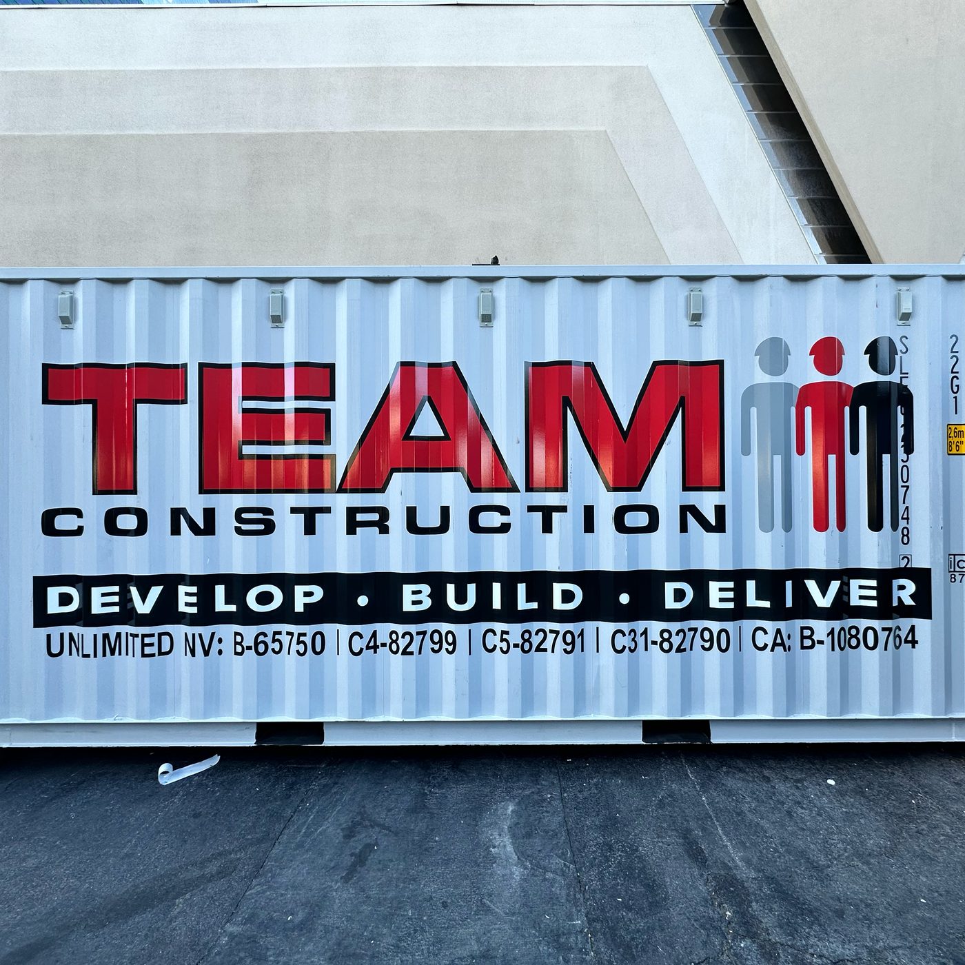 Real photo: a 20 ft shipping container lettered with a red and black company name, a three-figure logo, a slogan band and license numbers (product photo 2 of 4)